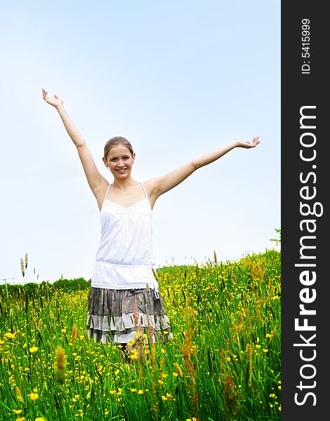 Happy woman on a meadow in front of the blue sky. Happy woman on a meadow in front of the blue sky