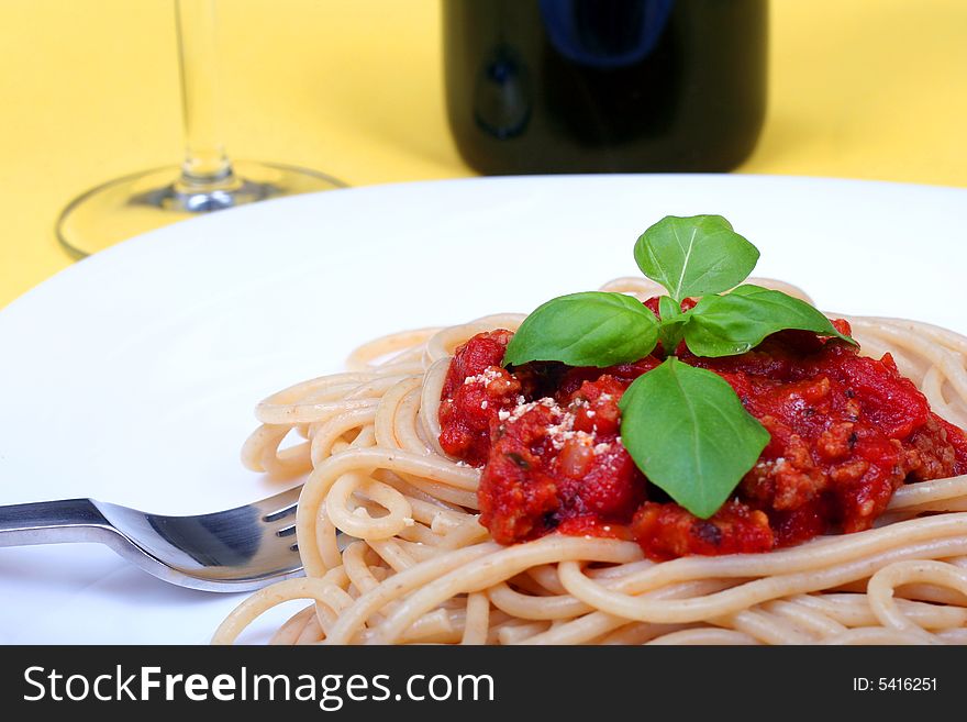 Spaghetti bolognese served on white plate and wine. Spaghetti bolognese served on white plate and wine