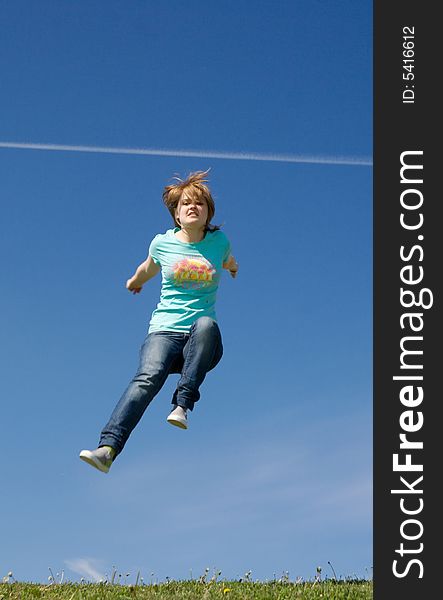 The young happy jumping girl on a background of the blue sky. The young happy jumping girl on a background of the blue sky