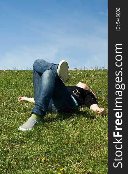 The Young Girl Laying On A Green Grass