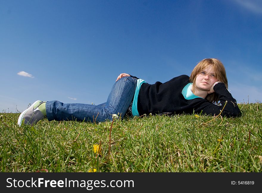 The young girl laying on a green grass