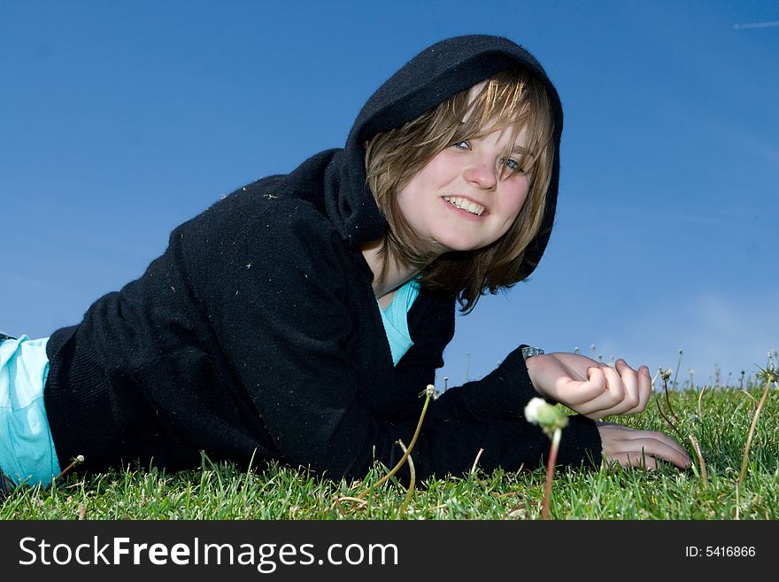 The young beautiful girl laying on a green grass. The young beautiful girl laying on a green grass