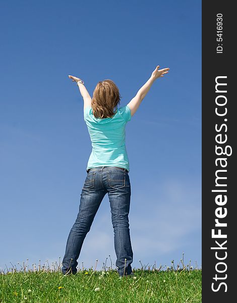 The young attractive girl standing on a green grass. The young attractive girl standing on a green grass