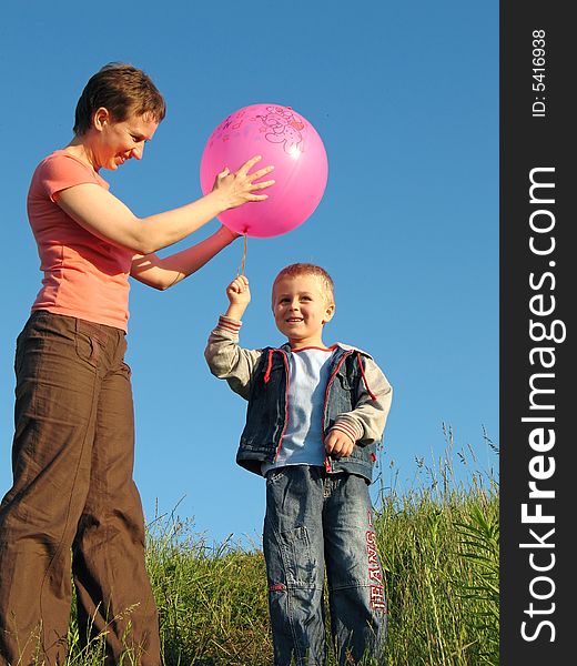 Child and mother play with red ball