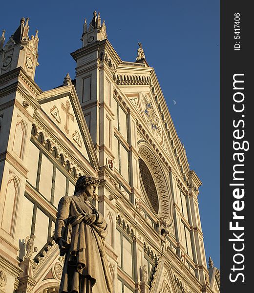 A view of the statue of Dante Alighieri and a glimpse of the facade of Santa Croce Church in Florence- Tuscany. A view of the statue of Dante Alighieri and a glimpse of the facade of Santa Croce Church in Florence- Tuscany