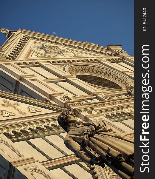 A view of the statue of Dante Alighieri and a glimpse of the facade of Santa Croce Church in Florence- Tuscany. A view of the statue of Dante Alighieri and a glimpse of the facade of Santa Croce Church in Florence- Tuscany