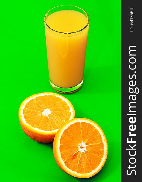 A tall glass of orange juice with oranges around it