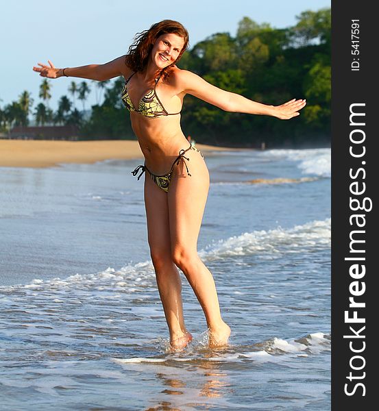 A young woman at the beach in the water. Jumping for joy with a bikini. Ideal Vactionshot. A young woman at the beach in the water. Jumping for joy with a bikini. Ideal Vactionshot.