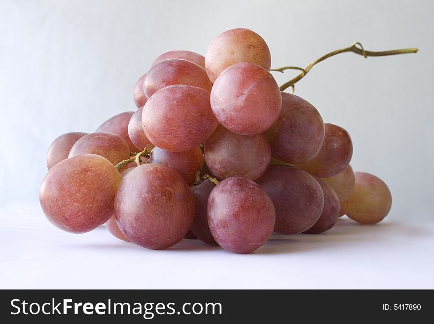Cluster of red grapes on white background