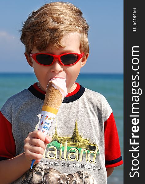 On seacoast the boy eats ice cream