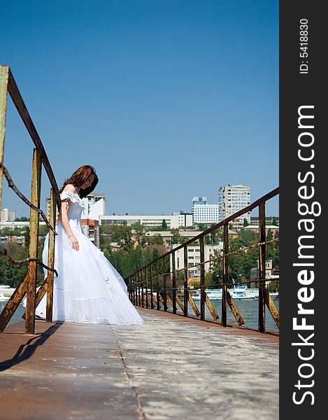 Bride on the old bridge looks down. Bride on the old bridge looks down