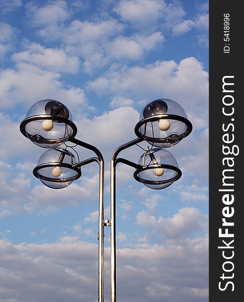 Street lamps with cloudy sky behind