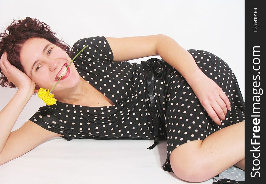 She is a happy young girl with a yellow flower and a black dress. She is a happy young girl with a yellow flower and a black dress.