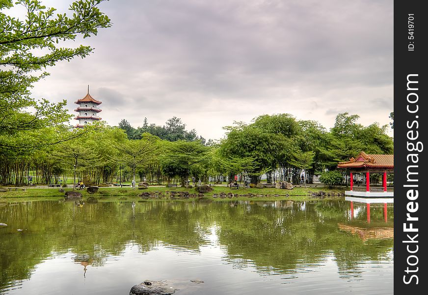 A traditional chinese pagoda and a pavilion on lake in a public park. A traditional chinese pagoda and a pavilion on lake in a public park