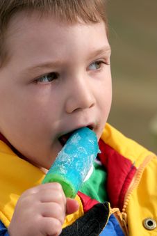 Small Boy Eating A Blue Popsicle Stock Photos