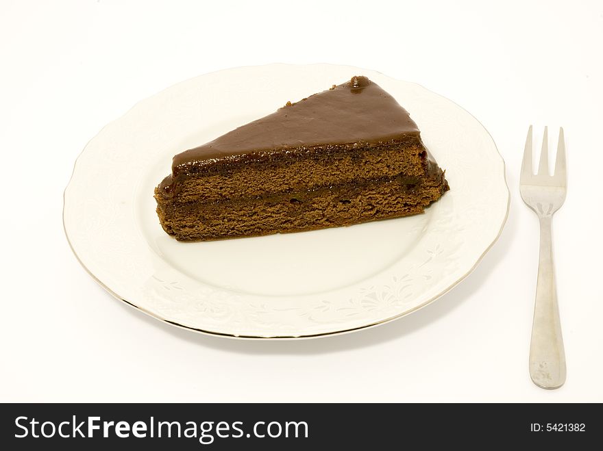 A plate of chocolate cake with a fork, arranged over white