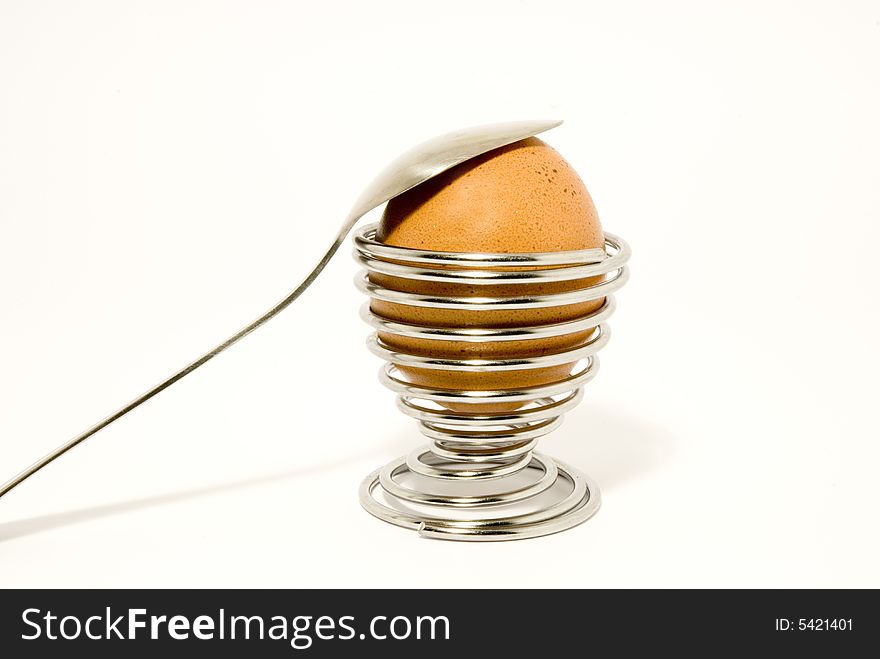 An egg and a spoon nfor breakfast, over white background