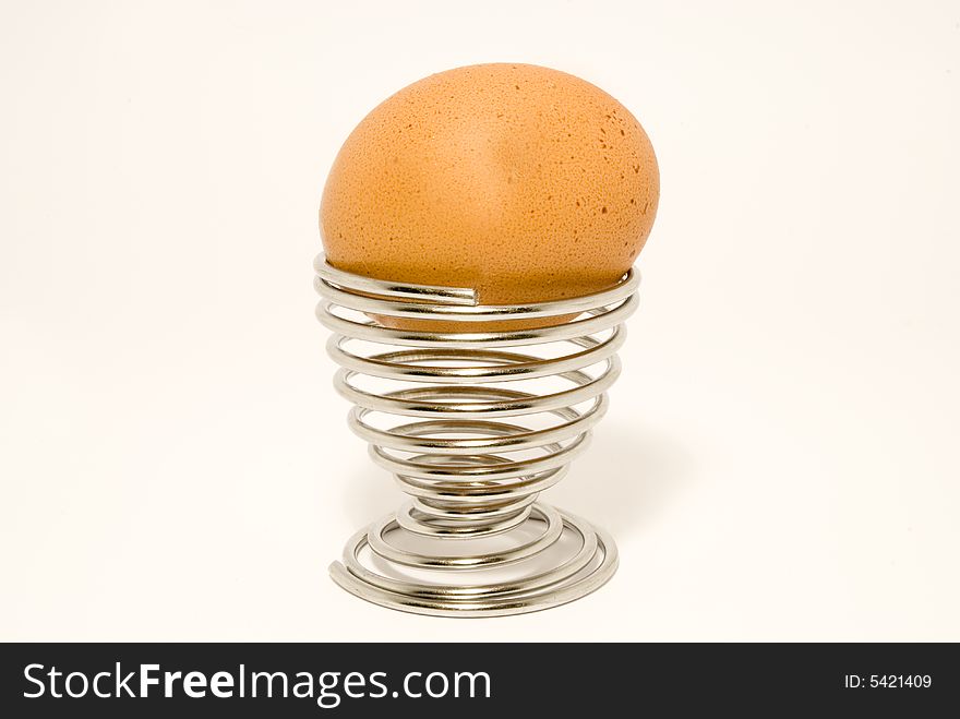 Breakfast egg in an egg cup, placed over white background