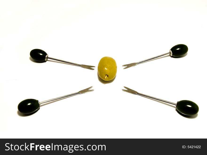 One olive surrounded by small forks. One olive surrounded by small forks