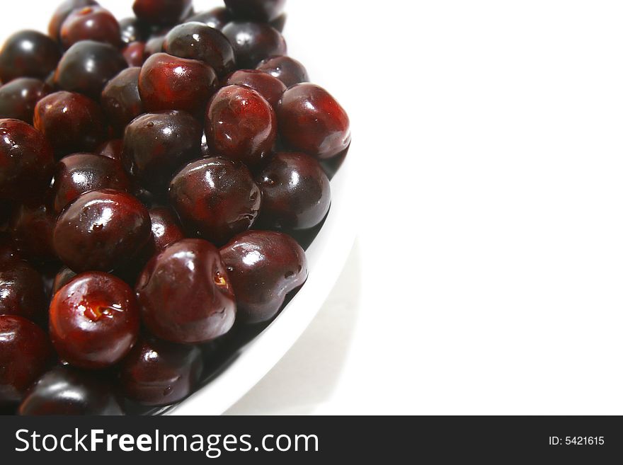 Sweet cherries in plate over white