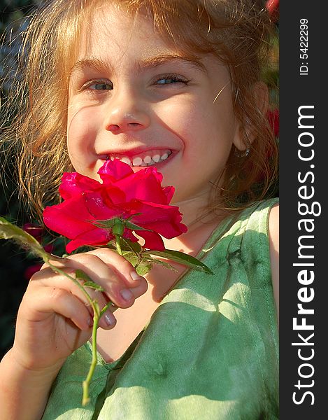 Beautiful little girl with a bright red rose. Beautiful little girl with a bright red rose