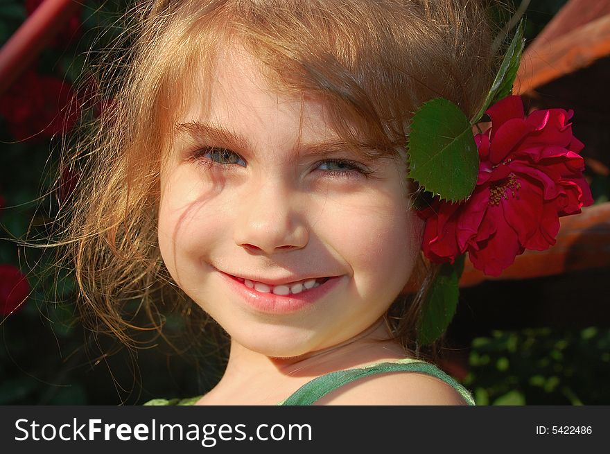Beautiful little girl with a bright red rose. Beautiful little girl with a bright red rose