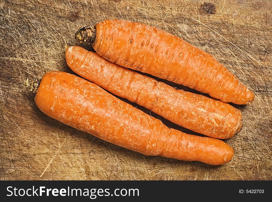 Three carrots on a cuttimg table. Three carrots on a cuttimg table.