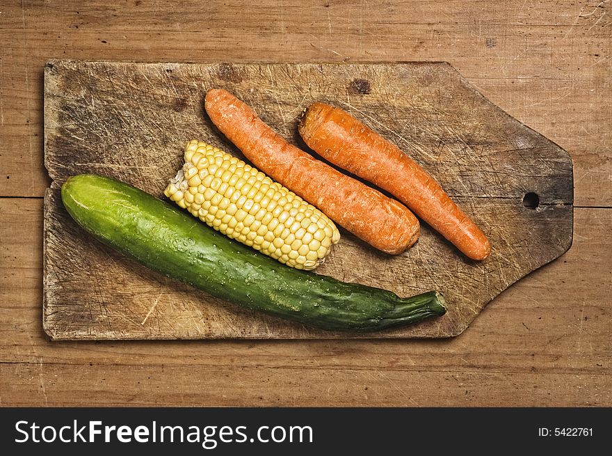 Carrots, corn and cucumber on cutting table. Carrots, corn and cucumber on cutting table.