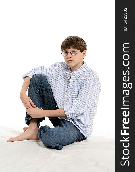 Cute boy with short hair and glasses, sitting with knee up and untucked shirt. Cute boy with short hair and glasses, sitting with knee up and untucked shirt.