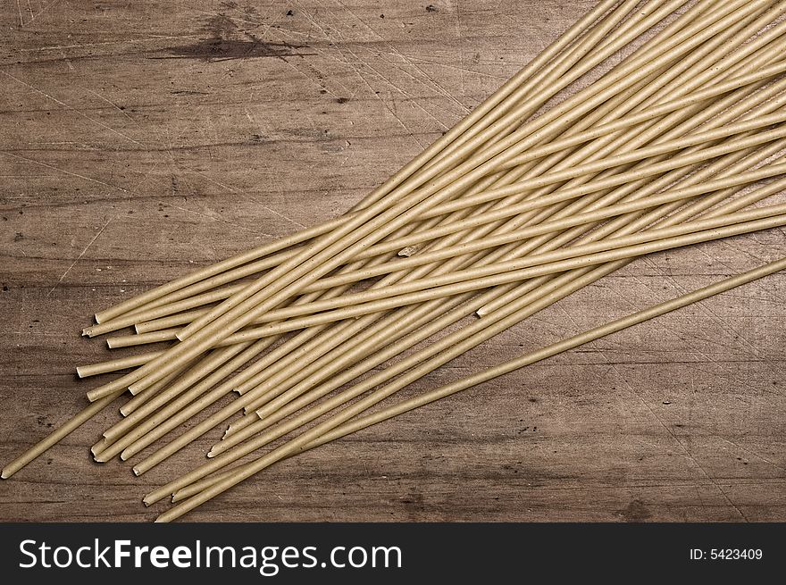 Italian spaguetti pasta dry, on wooden table.