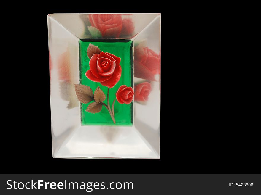 A bright red rose encased in plastic with reflections, isolated on black. A bright red rose encased in plastic with reflections, isolated on black