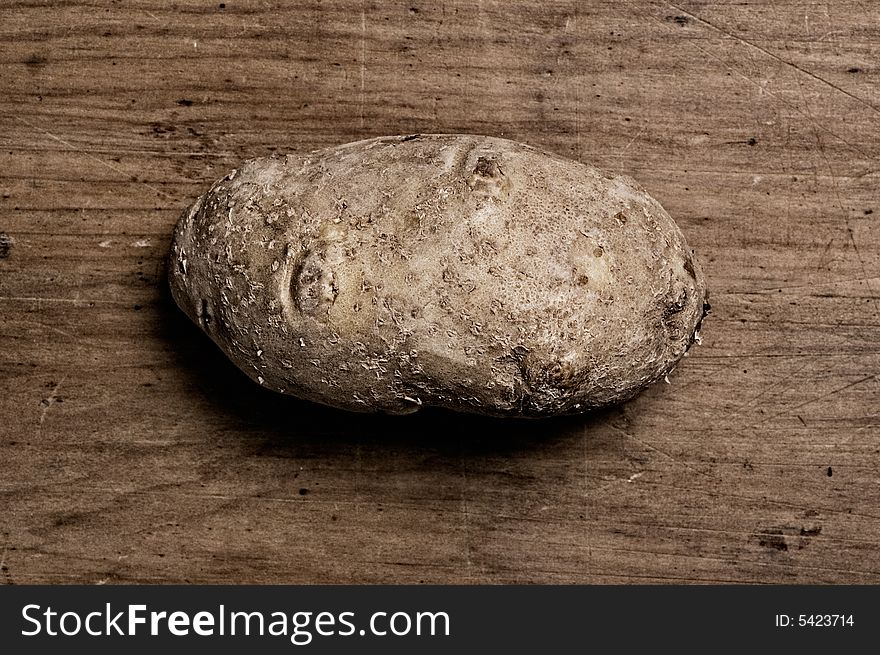 Potato on old wooden table.