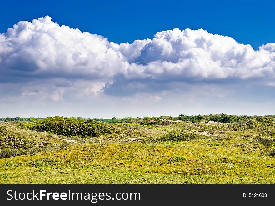 Landscape with dunes and clouds over blue sky. Landscape with dunes and clouds over blue sky