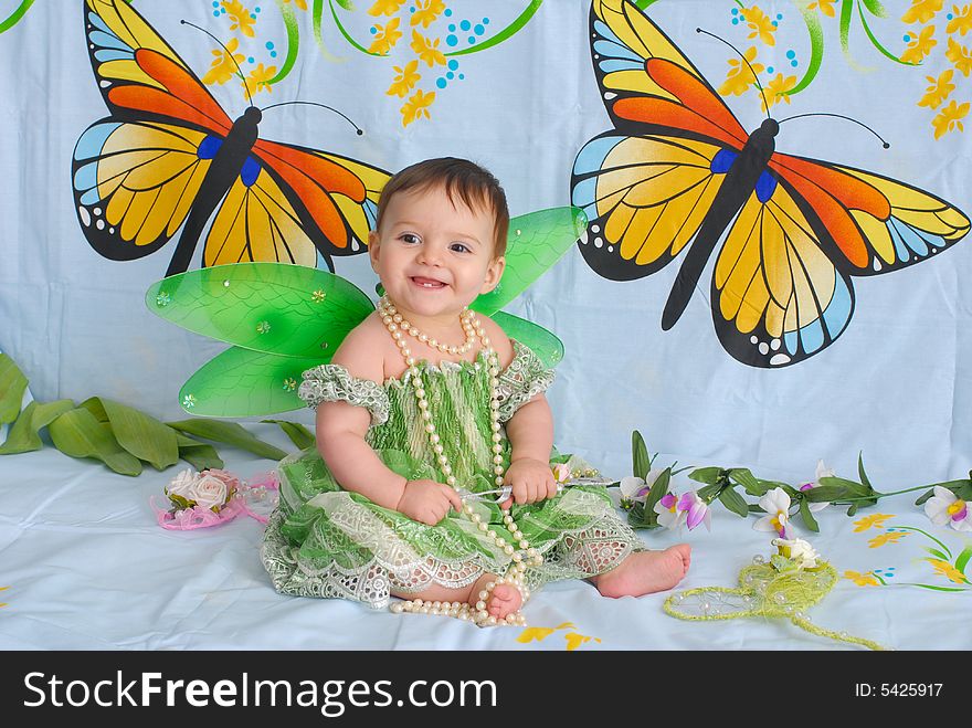 Portrait of a sweet smiling baby girl wearing fancy green dress with butterfly wings. Portrait of a sweet smiling baby girl wearing fancy green dress with butterfly wings