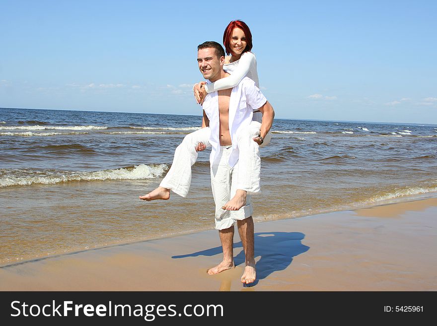 Beautiful yound couple relaxing on the beach. Beautiful yound couple relaxing on the beach