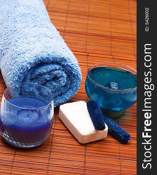 Spa scenery - blue towel, body oil, soap and candle