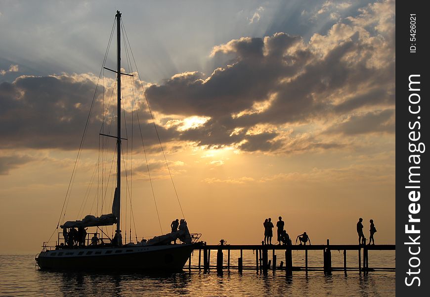 The Black sea, the sunset, and the silhouette of the yacht near the mooring line. The Black sea, the sunset, and the silhouette of the yacht near the mooring line