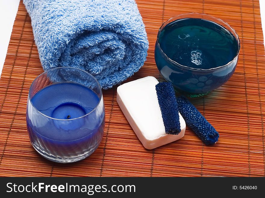 Spa scenery - blue towel, body oil, soap and candle