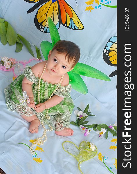 Portrait of a sweet smiling baby girl wearing fancy green dress with butterfly wings. Portrait of a sweet smiling baby girl wearing fancy green dress with butterfly wings