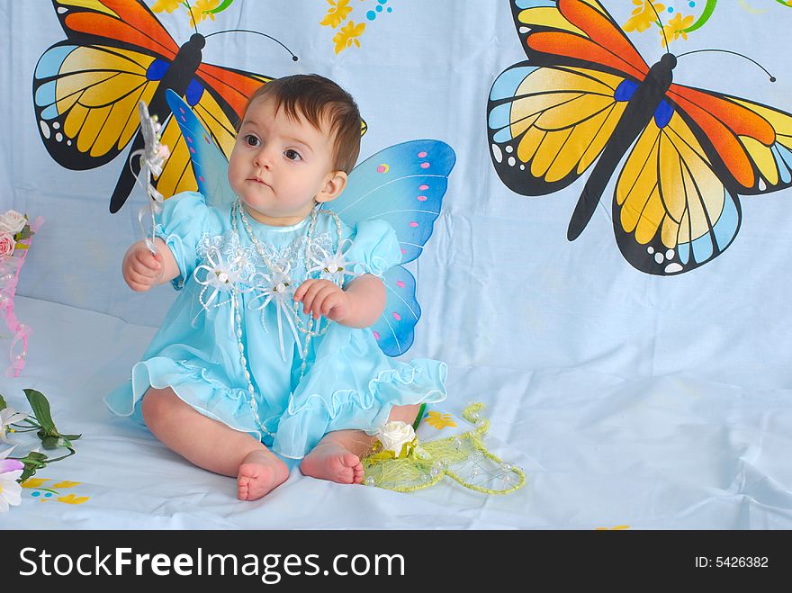 A picture of a sweet little girl in a fancy blue dress with butterfly wings. A picture of a sweet little girl in a fancy blue dress with butterfly wings