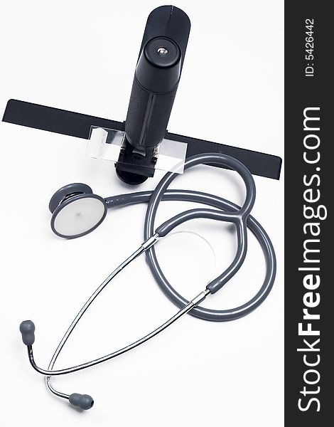 Stethoscope and microscope  - medical tools on  glass table