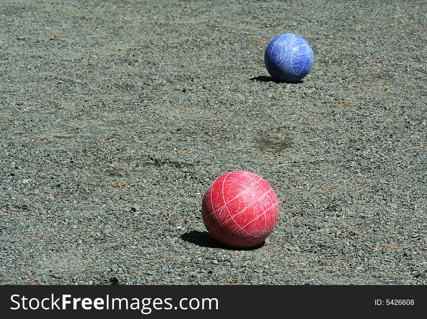 A Red and blue bocce balls on a court