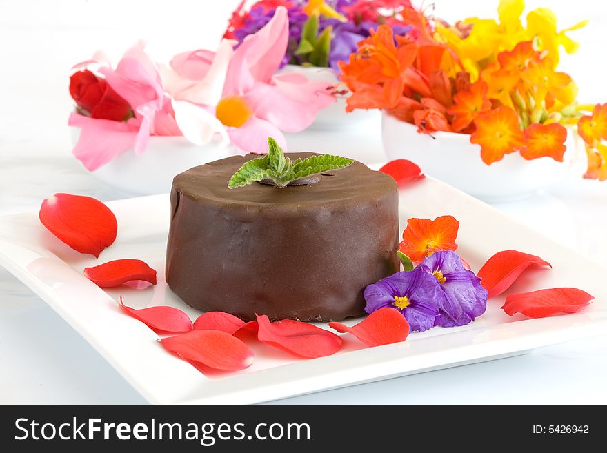 Chocolate cake on white dish with flower background. Chocolate cake on white dish with flower background