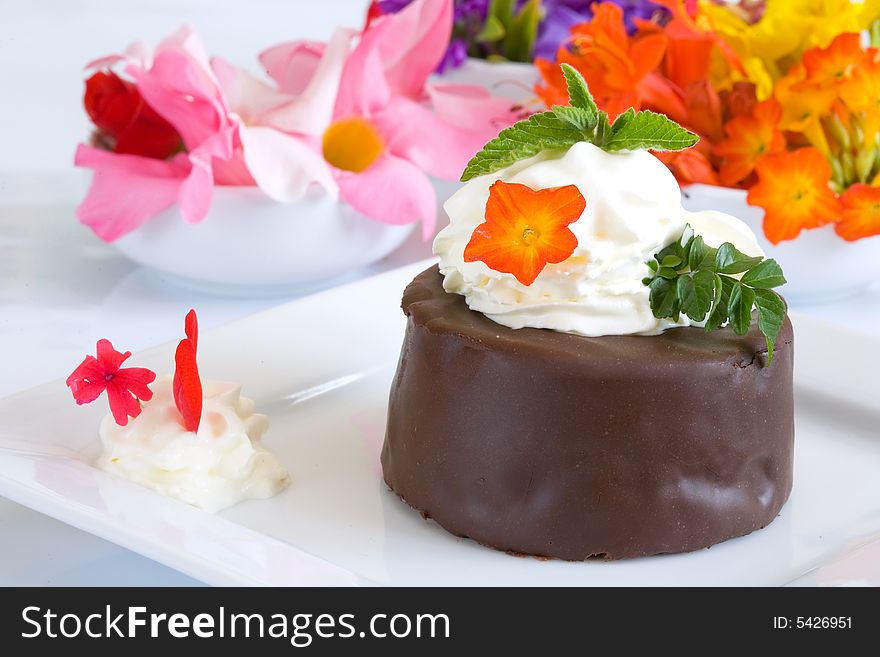 Chocolate cake on white dish with flower background. Chocolate cake on white dish with flower background