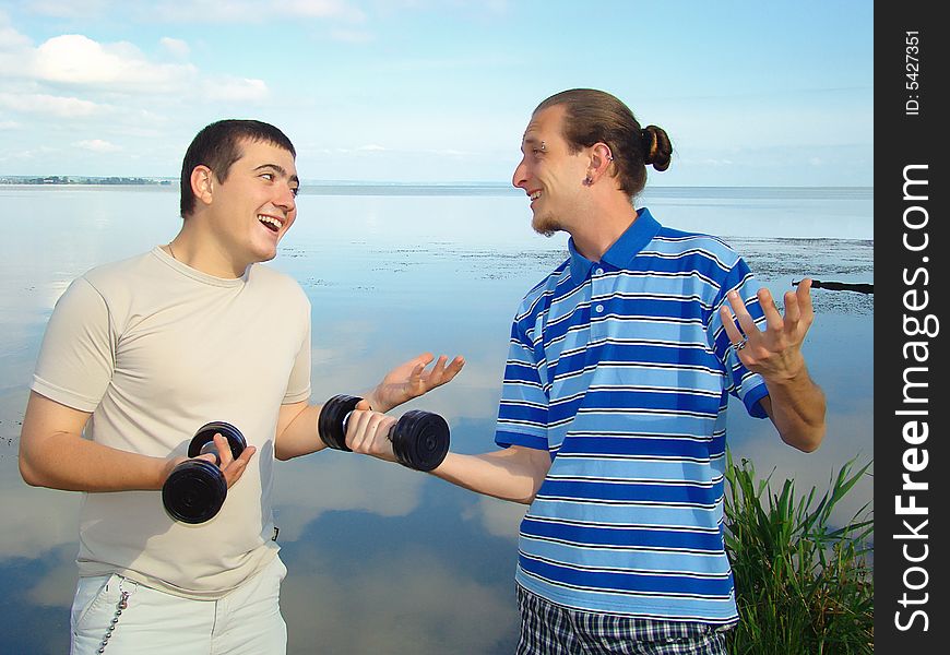 Youth funs. Two fellows with dumb-bells. Healthy lifestyle. Youth funs. Two fellows with dumb-bells. Healthy lifestyle.