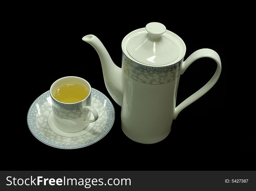 Isolated cup and teapot  on black