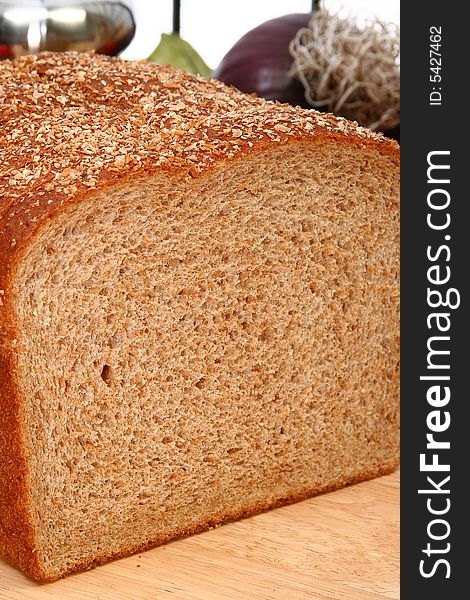 Whole wheat bread sliced on cutting board in kitchen or deli.