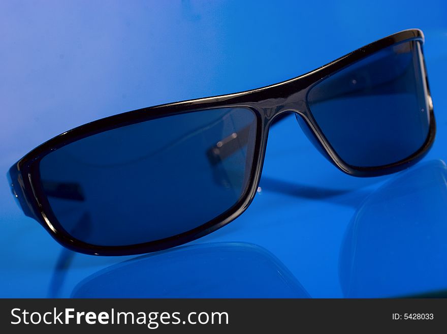 Black sunglasses over blue background