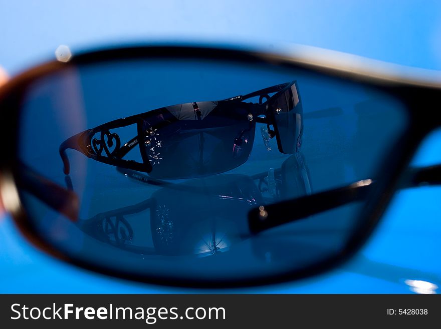 Black sunglasses over blue background