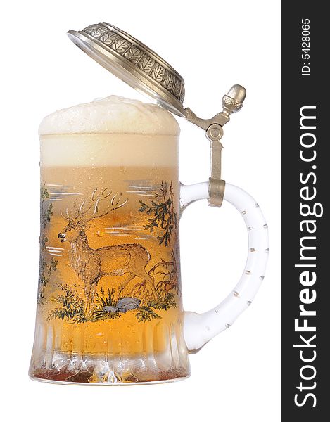 Souvenir glass with the image of the wild nature, filled by beer, with the slightly opened cover. Souvenir glass with the image of the wild nature, filled by beer, with the slightly opened cover